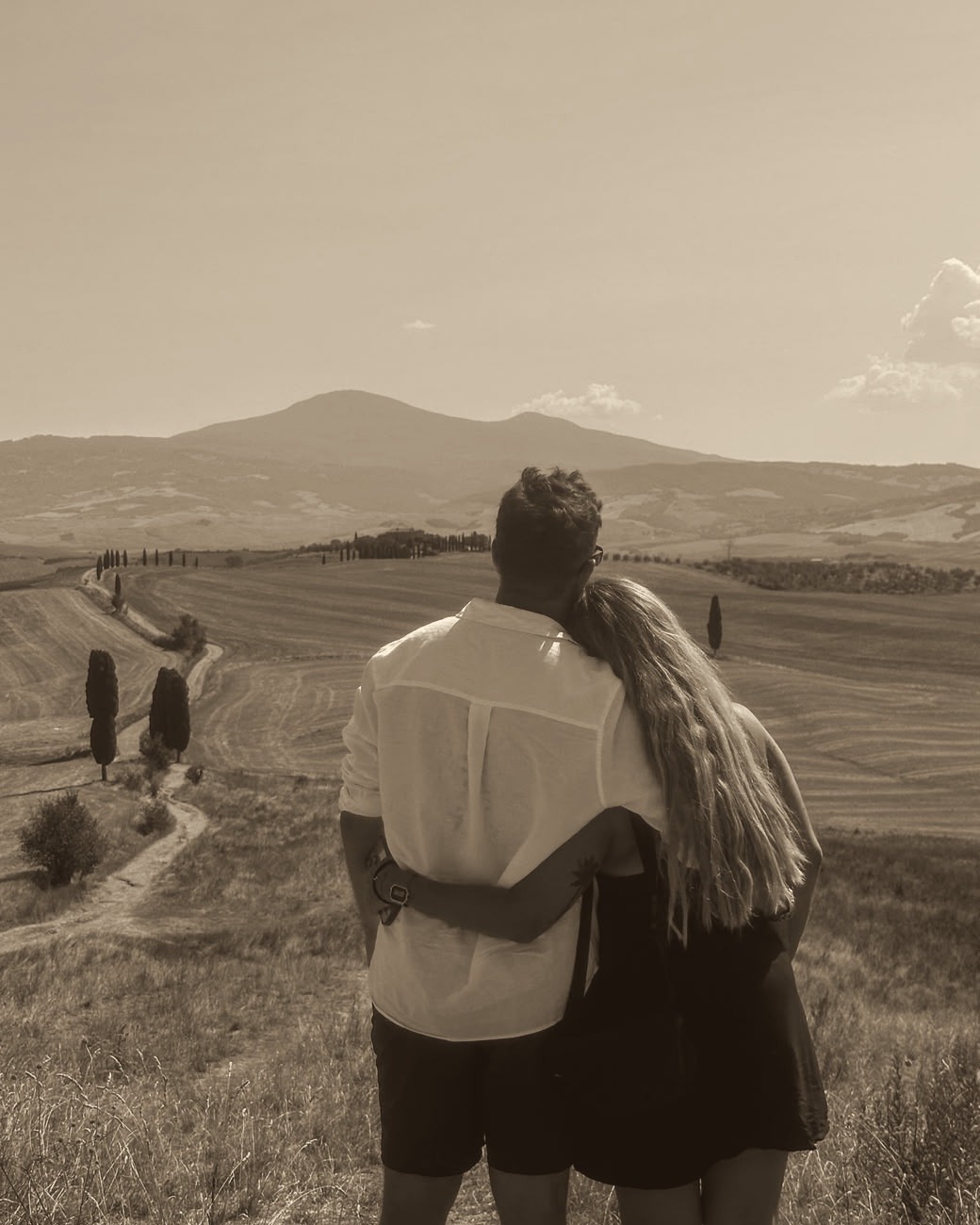 Gre y Agus abrazados mirando los campos de la Toscana